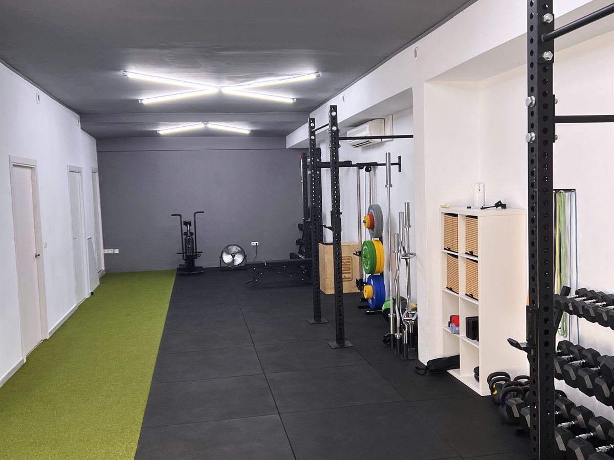 Sala principal de entrenamiento en Nexus Gines con césped funcional y luces corporativas